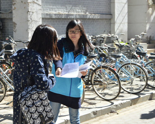 宿舍区展台前总队工作人员为同学讲解志愿者实名注册流程 宿舍区展台前总队工作人员为同学讲解志愿者实名注册流程