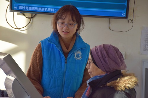 2志愿者协助患者操作设备 2志愿者协助患者操作设备
