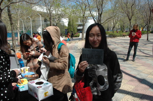 展台工作人员向活动参与同学赠送纪念品 展台工作人员向活动参与同学赠送纪念品