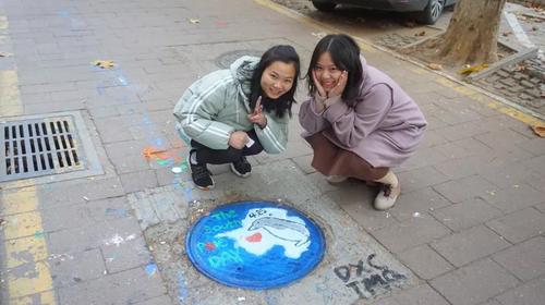 2完成绘画的志愿者和色彩缤纷的井盖 2完成绘画的志愿者和色彩缤纷的井盖