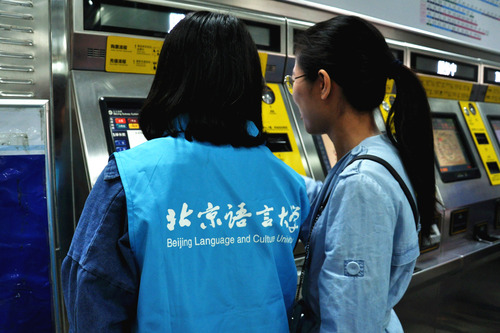 1志愿者帮助乘客使用自动售票机 1志愿者帮助乘客使用自动售票机