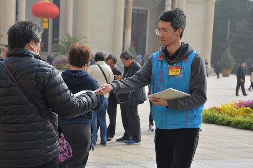 志愿者为观众分发纪念册 志愿者为观众分发纪念册