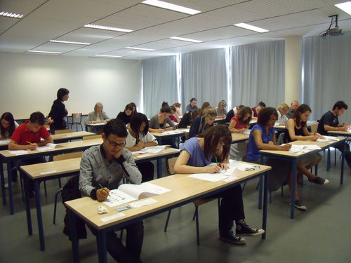 考场内考生专心答题、监考教师正在巡视 考场内考生专心答题、监考教师正在巡视