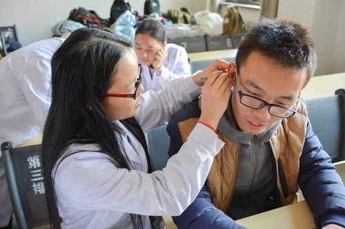 中医为同学们进行压豆疗法 中医为同学们进行压豆疗法