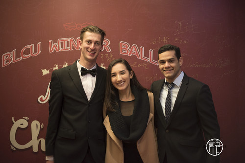 1参加舞会的留学生在背景板处合影留念