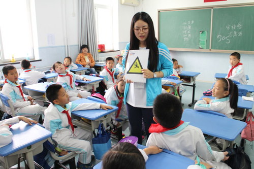 志愿者向孩子们展示防震减灾标志 志愿者向孩子们展示防震减灾标志